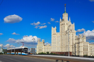 Fototapeta na wymiar Russia, Moscow - July 2022: View of Kotelnicheskaya Embankment Building and tram from Bolshoy Ustinsky Bridge in Moscow