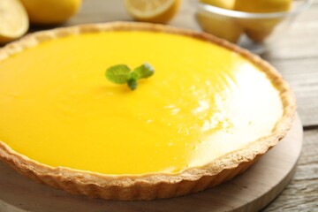 Delicious homemade lemon pie with mint on wooden table, closeup