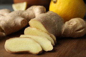 Cut ginger and lemon on wooden board, closeup