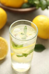 Cool freshly made lemonade in glass on light table, closeup