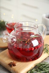 Tasty hot cranberry tea with rosemary and anise on table