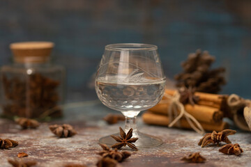 foreground crystal glass with aniseed liqueur, rum, tequila with aniseed, cinnamon sticks tied with...
