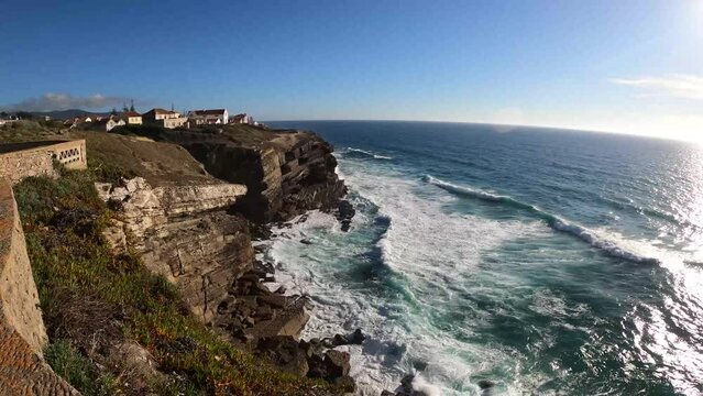 Ocean waves crashing on the high cliffs in Azenhas do Mar, Portugal