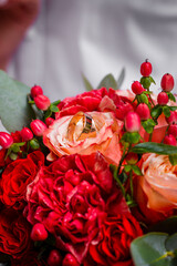 a bouquet of red roses with gold rings