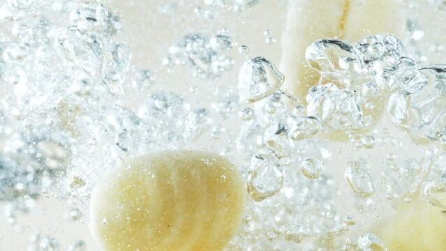 Super slow motion of falling potatoes gnocchi into water. Filmed on high speed cinema camera, 1000 fps. Speed ramp effect.