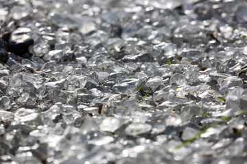Background from a transparent glass stone. Artificial turf. Pieces of glass. Pure crystal quartz