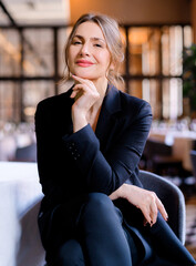 Portrait of smiling successful businesswoman looking into camera sitting in the restaurant....