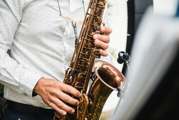Obraz premium Crop man playing saxophone on stage