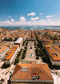 Vertical aerial drone view of Rossio Square and Baixa District in Lisbon, Portugal with major landmarks visible