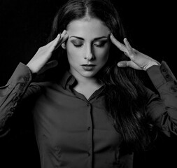 Beautiful serious concentrated thinking young woman with closed eyes solving the questions with fingers on the scales on empty black studio copy space. Closeup portrait.