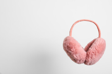 Stylish winter earmuffs on white background, space for text