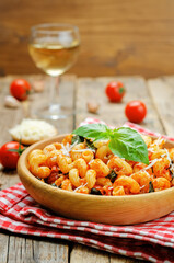 Tomato basil pasta in a plate on a wood background