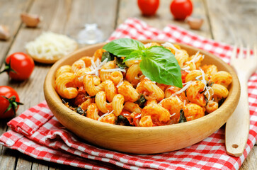 Tomato basil pasta in a plate on a wood background