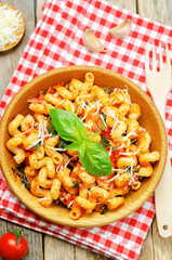 Tomato basil pasta in a plate on a wood background