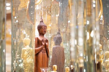 standing Buddha statue made of wood was placed between the smaller golden Buddha images of apostles.
