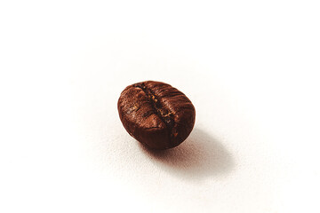 Extreme closeup of a roasted coffee bean on white background