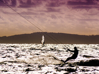 Kite surfer riding waves. Kiteboarding sport.