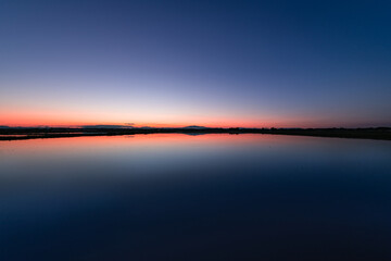 日本　栗駒山と夕焼けで水鏡の春の田園風景