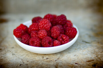 raspberries in a bowl on a wooden table