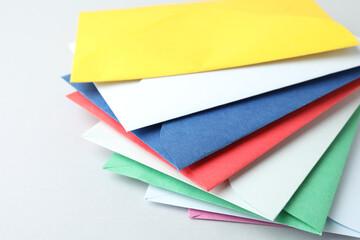 Colorful paper envelopes on light background, closeup