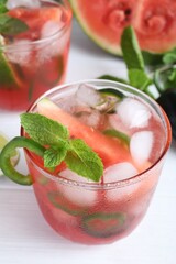 Spicy cocktail with jalapeno and mint on white wooden table