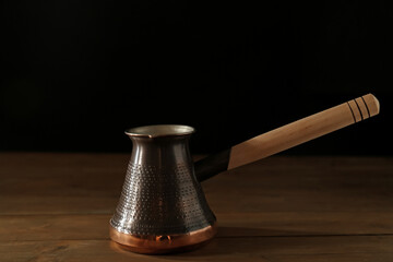 Beautiful copper turkish coffee pot on wooden table