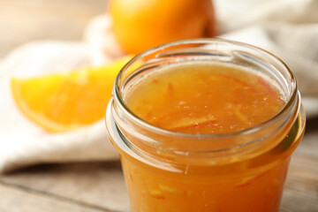 Homemade delicious orange jam on table, closeup view