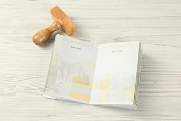 Moldova, Ceadir-Lunga - June 13, 2022: Wooden stamp and open passport with blank visa pages on...