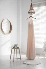 Beautiful wedding dress, shoes and flowers in room