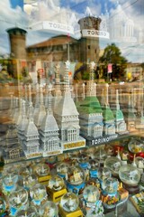 Charming blurred  reflection through souvenirs shop window of city icons at Castle square Turin Italy