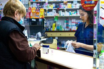 Farmaceutica atendiendo al publico