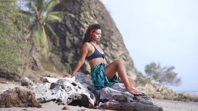 Beautiful island girl in traditional polynesian pareo skirt and hawaiian flower. Concept of tropical paradise island, exotic travel vacation getaway, romantic honeymoon destination.
