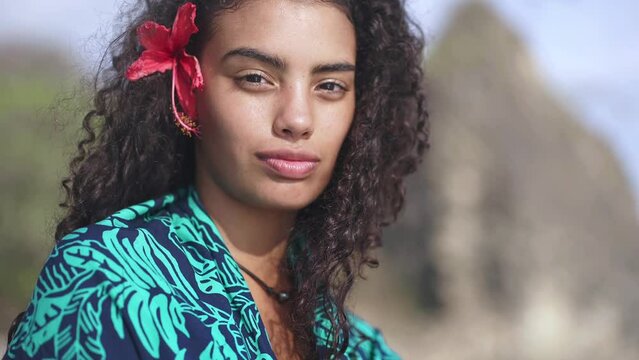 Portrait of beautiful island girl with hawaiian flower.  Concept of polynesia culture travel, exotic beach vacation, dream getaway to Tahiti.