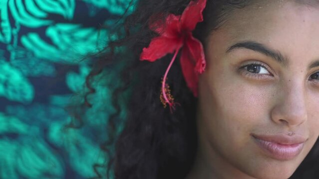 Young island woman with traditional hawaiian flower on tropical beach. Concept of paradise island, exotic vacation getaway, dream travel to Tahiti, French Polynesia.
