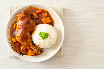 chicken stew with tomatoes, onions, carrot and potatoes on plate with rice