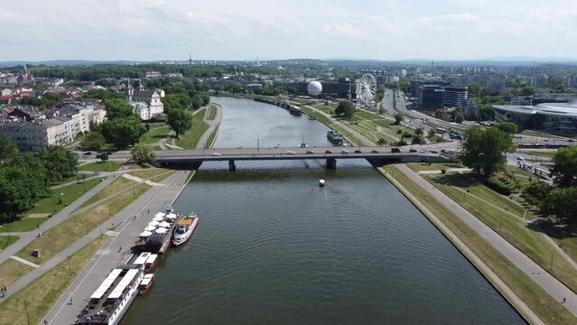 Flyover of Wisła Vistula River near the city centre of Krakow, Poland, a Polish cultural capital, with medieval and renaissance architecture - 4K 30FPS Smooth Tracking Forwards