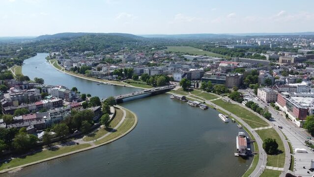 Flyover of Wisła Vistula River near the city center of Krakow, Poland, a Polish cultural capital, with medieval and renaissance architecture - 4K 30FPS Smooth Tracking Forwards