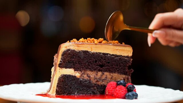 woman eat slice of Chocolate cake in slow motion blurry background restaurant