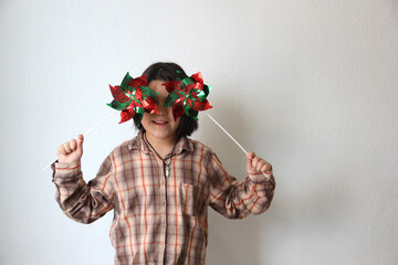 10-year-old Latina Hispanic girl plays with green white and red pennant flags and pinwheel to...