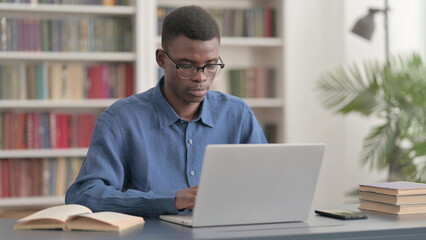 Young African Man Working on Laptop in Office