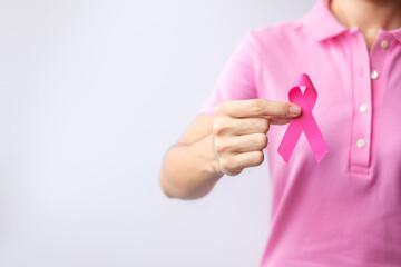 Pink October Breast Cancer Awareness month, woman hand hold pink Ribbon and wear shirt for support...