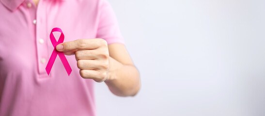 Pink October Breast Cancer Awareness month, woman hand hold pink Ribbon and wear shirt for support...