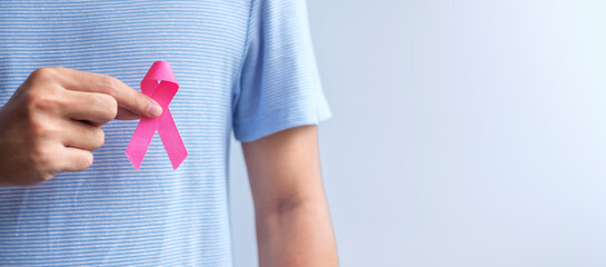 Pink October Breast Cancer Awareness month, man hold pink Ribbon for support people life and illness. National cancer survivors month, Mother and World cancer day concept - obrazy, fototapety, plakaty