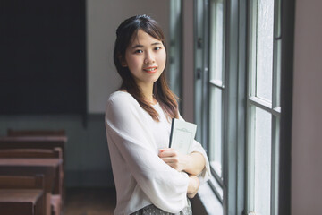 ノートを抱えて微笑む女性　School