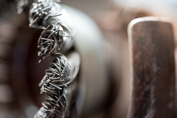 Macro selective focus on the bristle ends of a wire brush wheel on a grinder.