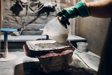 Artisan craftsman pour liquid plastic mask based on plaster cast. Gypsum mold and plastic mask...