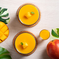 Delicious mango panna cotta mousse pudding on white table background.