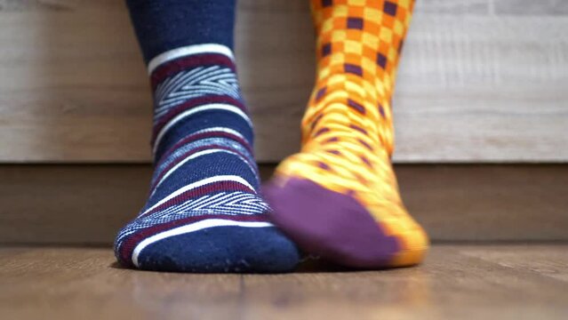 Men's legs and bright socks. Different socks as symbol of down syndrome. Down syndrome awareness concept.