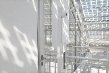 Face recognition system with camera in front of office in white interior indoor door