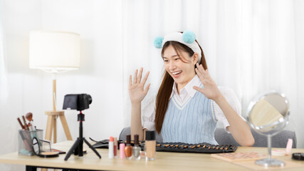 Beautiful woman with a social media influence is greeting the audience for recording vlog video...